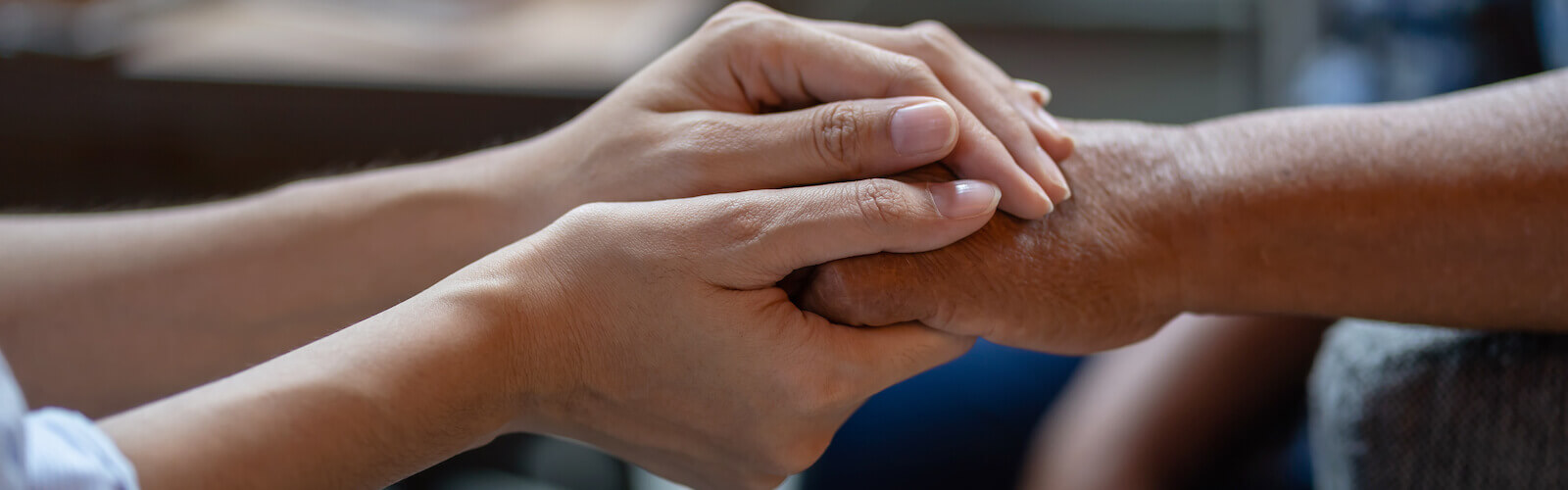 caregiver holding senior hand