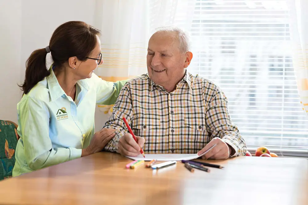 senior in memory care talking with a caregiver