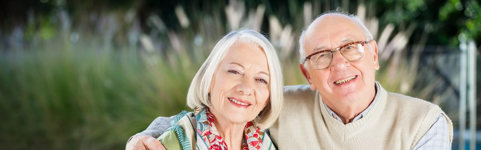 senior couple smiling sitting outside