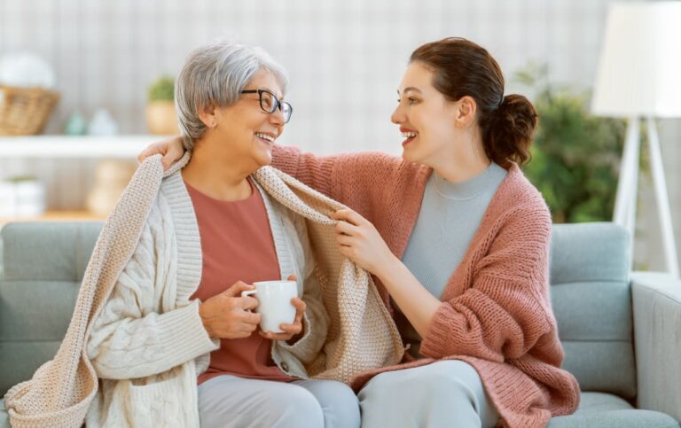 woman putting blanket on senior