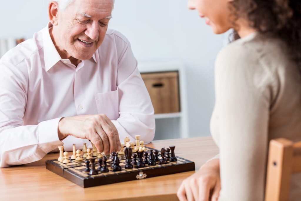 senior and young woman playing chess