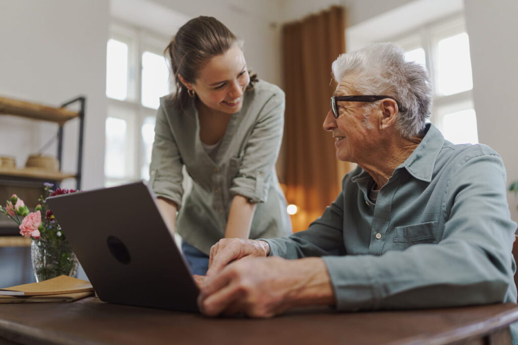 woman and senior man on laptop