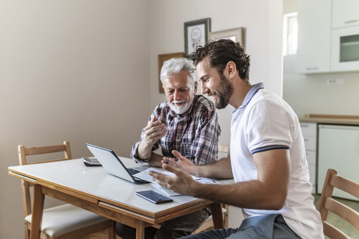 senior man and young man on laptop