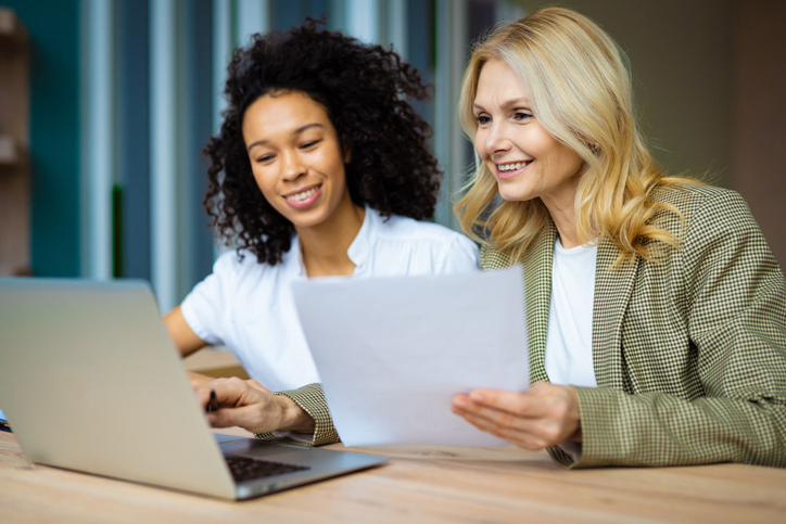 Beautiful adult businesswomen sitting at computer desk in the office
